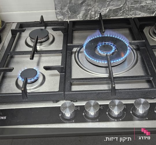 כיריים גז עם להבות כחולות ומתגים כסופים